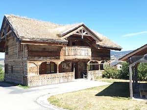 En fin d’été, sous un grand ciel bleu, le chaler Ker Béla construit de bois anciens, ses terrasses, et le kiosque dans le jardin.