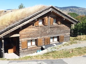 Con los picos de la Alta Cerdaña de fondo, el chalet Ker Cambre d’Aze muestra una de sus terrazas y su techo vegetal.