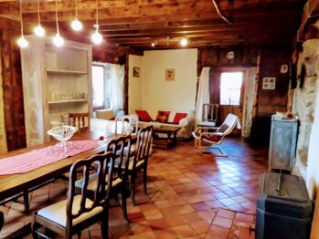 La salle de séjour du gîte Ker Carlines, sa grande table en bois pour les repas et le poêle à bûches